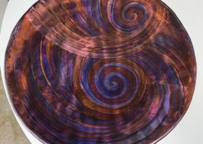 Round brass wall hanging with swirled purple and red finish image
