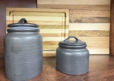 Two black canisters paired with two wood cutting board image
