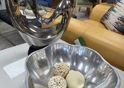 Silver heart sculpture next to a silver scalloped bowl image