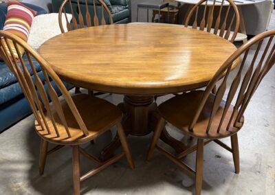 Round wood table with four round top spindle chairs image