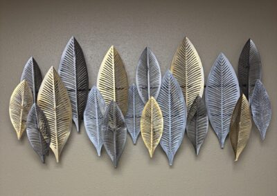 Metal wall sculpture of silver and gold abstract leaves image